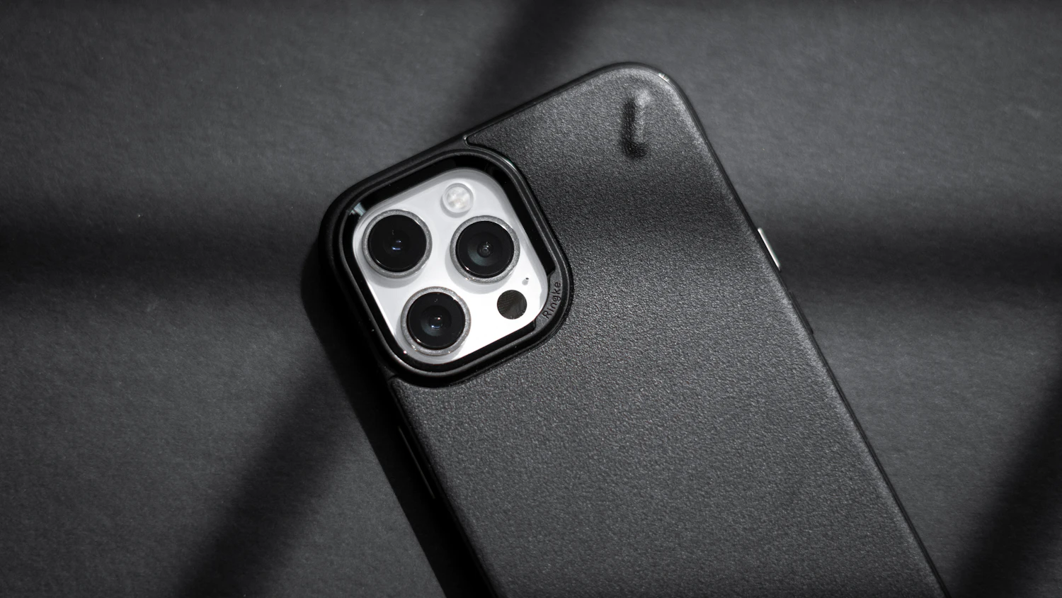 Grip Rib Case in Graphite lying on a dark grey desk