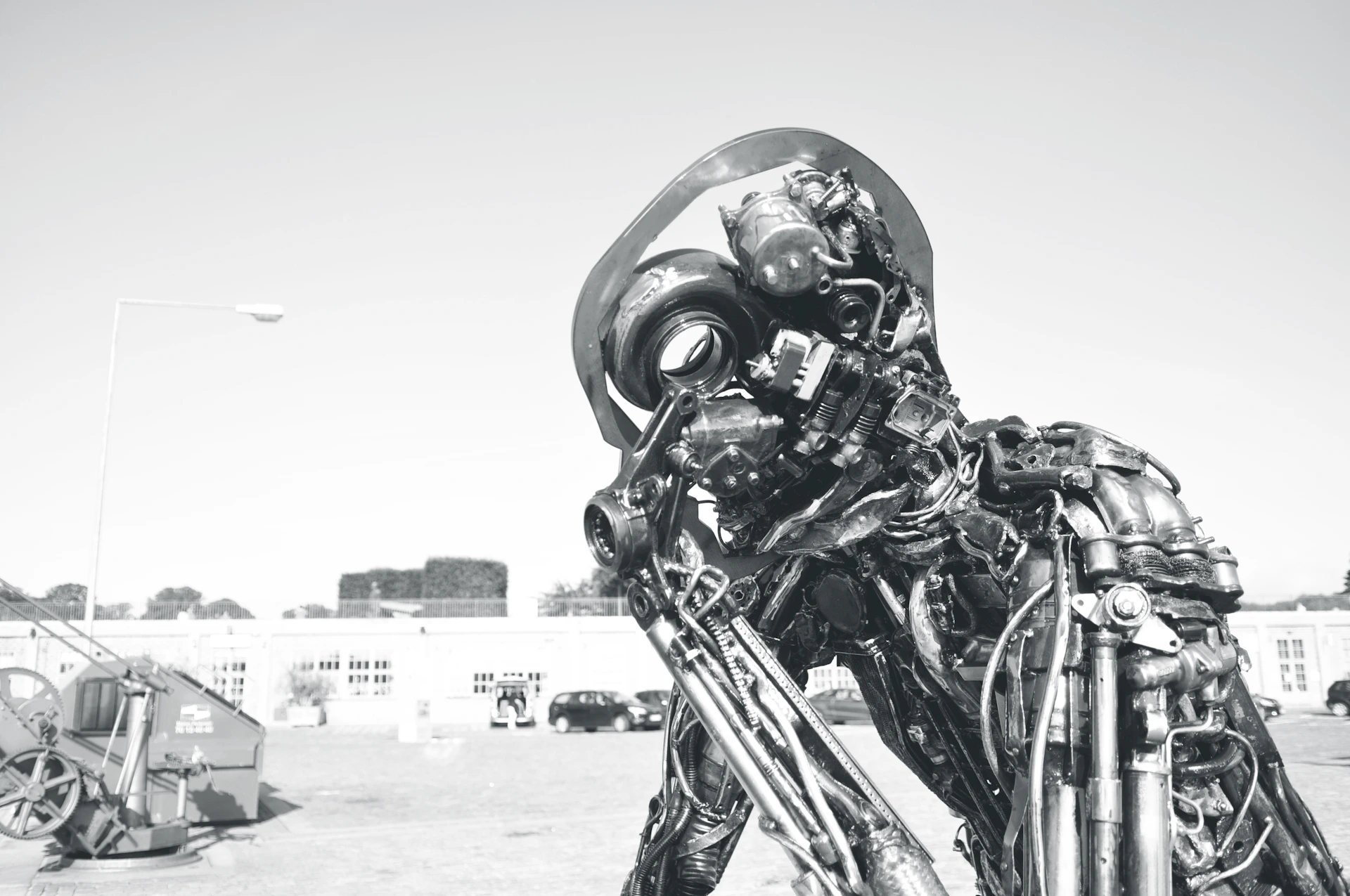 An outdoor installation of a large montage crafted from discarded mechanical parts, set against a natural backdrop in Obersdorf.