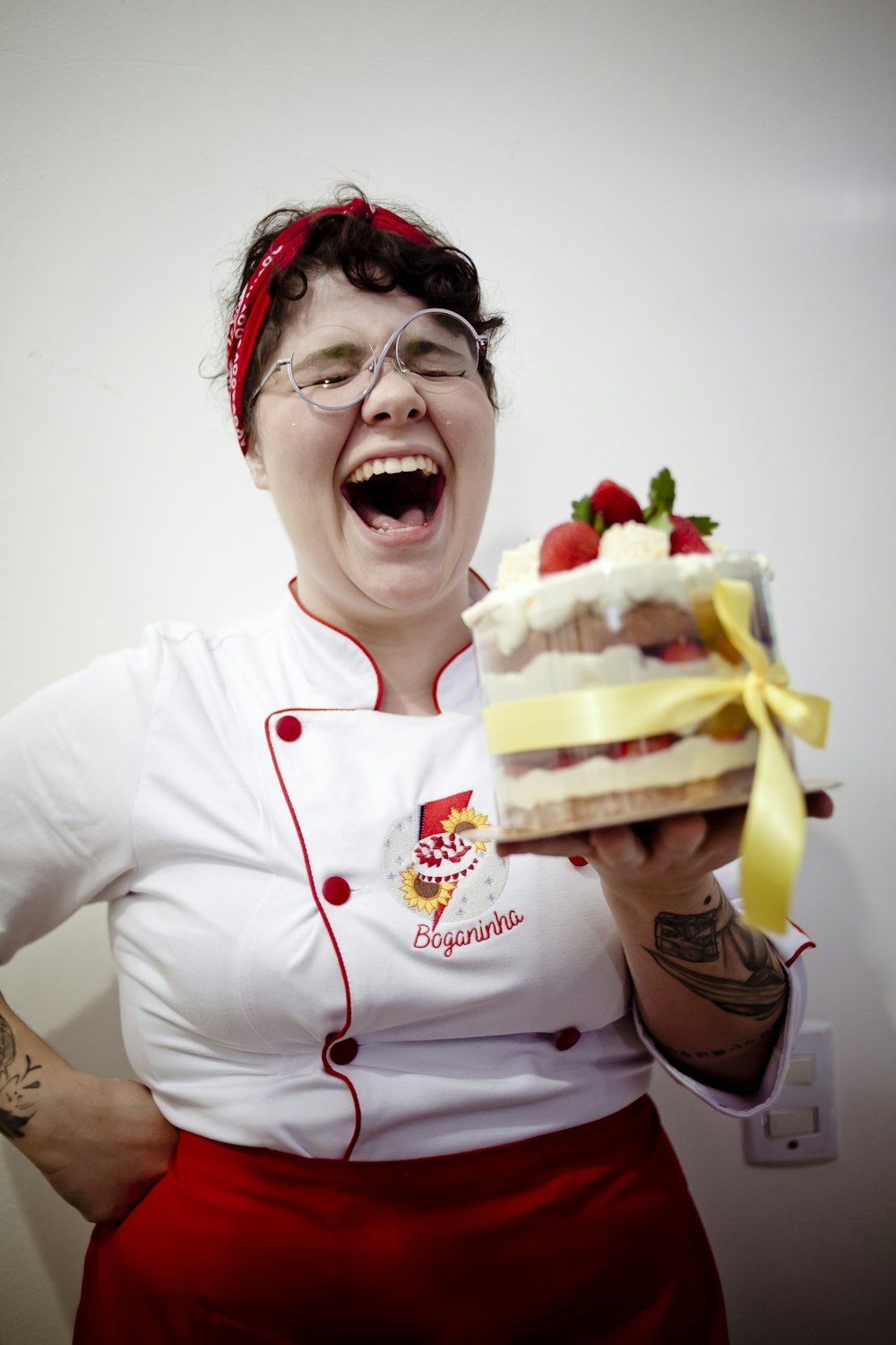 woman in white crew neck long sleeve shirt holding sliced of cake