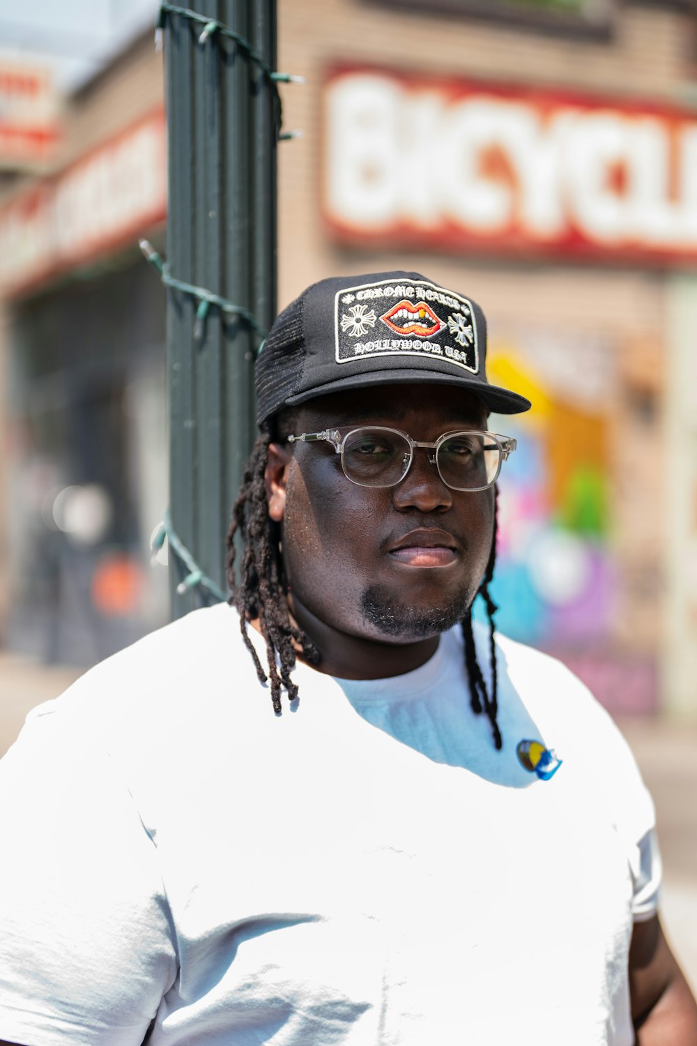 man in white crew neck shirt wearing black and white fitted cap