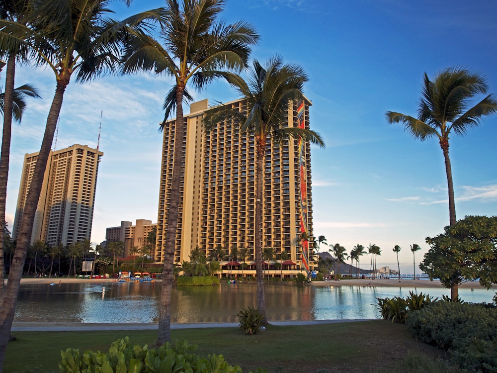 a large hotel with palm trees in front of it