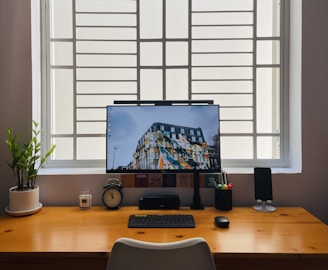 black flat screen computer monitor on brown wooden desk