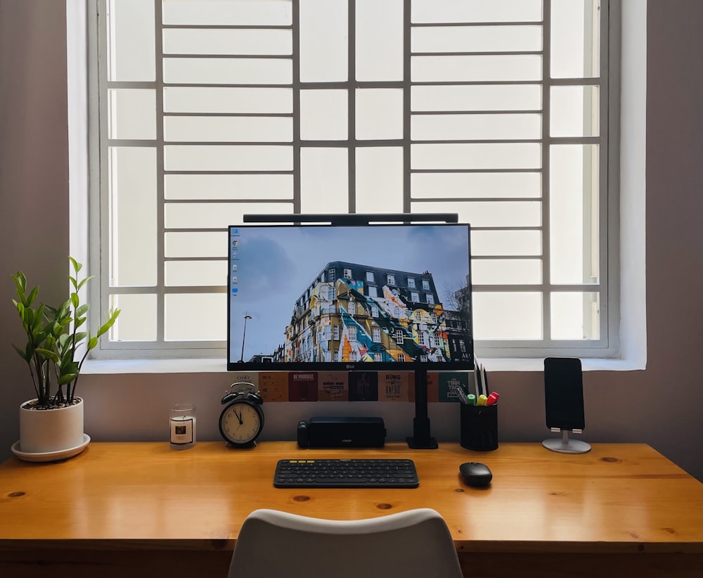 black flat screen computer monitor on brown wooden desk