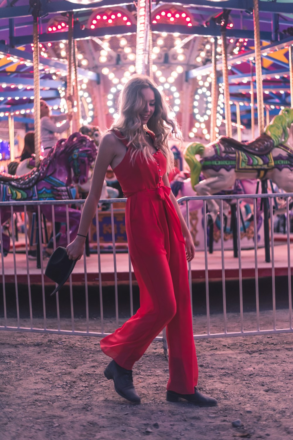 girl in red dress standing near carousel during daytime