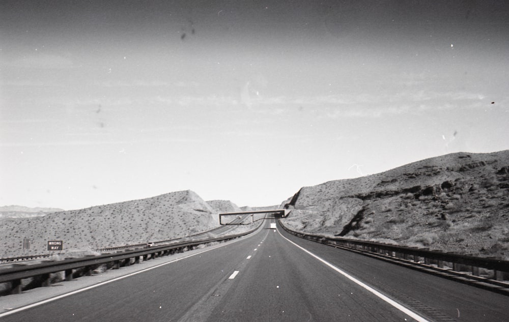 grayscale photo of road near mountain