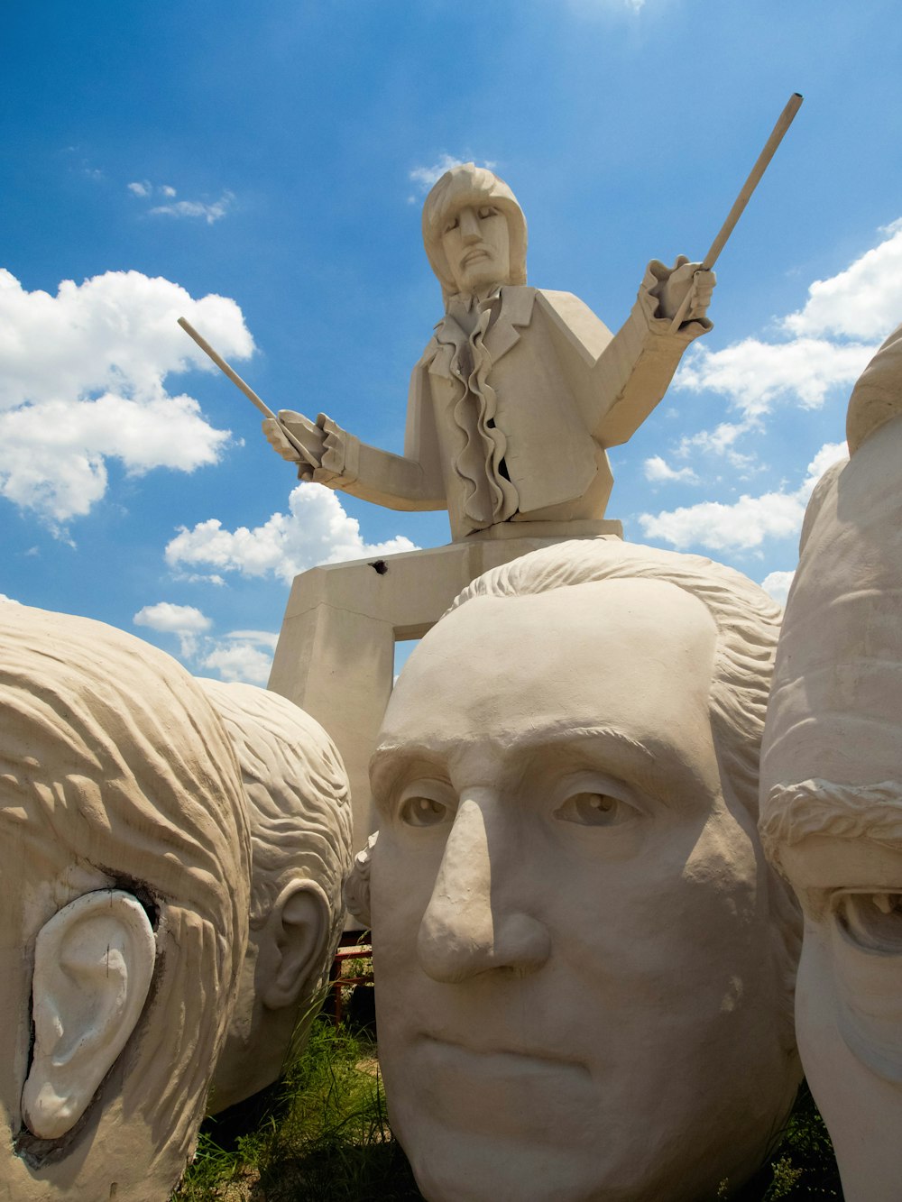 man holding stick statue during daytime