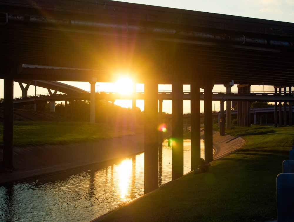 Braune Holzbrücke über den Fluss bei Sonnenuntergang