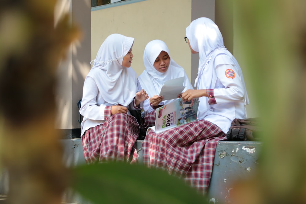 2 women in hijab sitting on chair