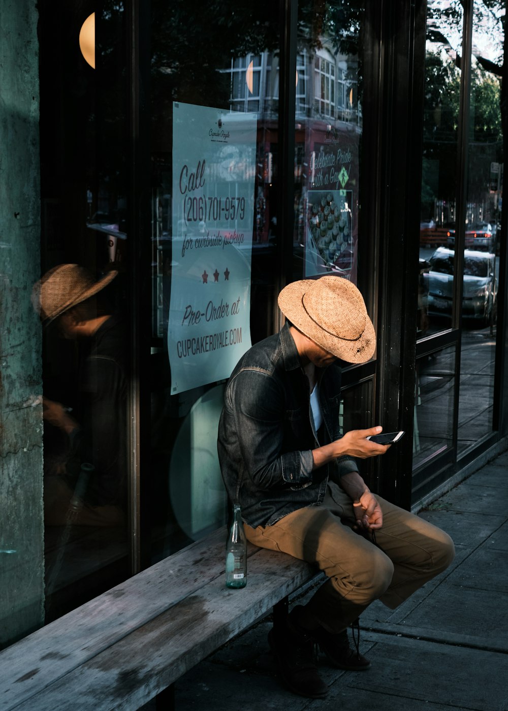 man in black leather jacket and brown fedora hat sitting on chair