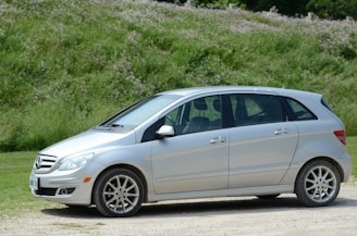 silver sedan on green grass field during daytime