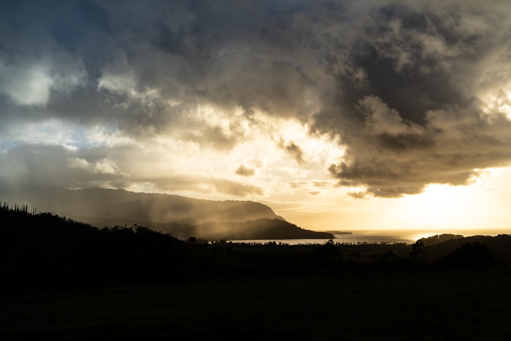 silhouette de montagne sous ciel nuageux pendant la journée