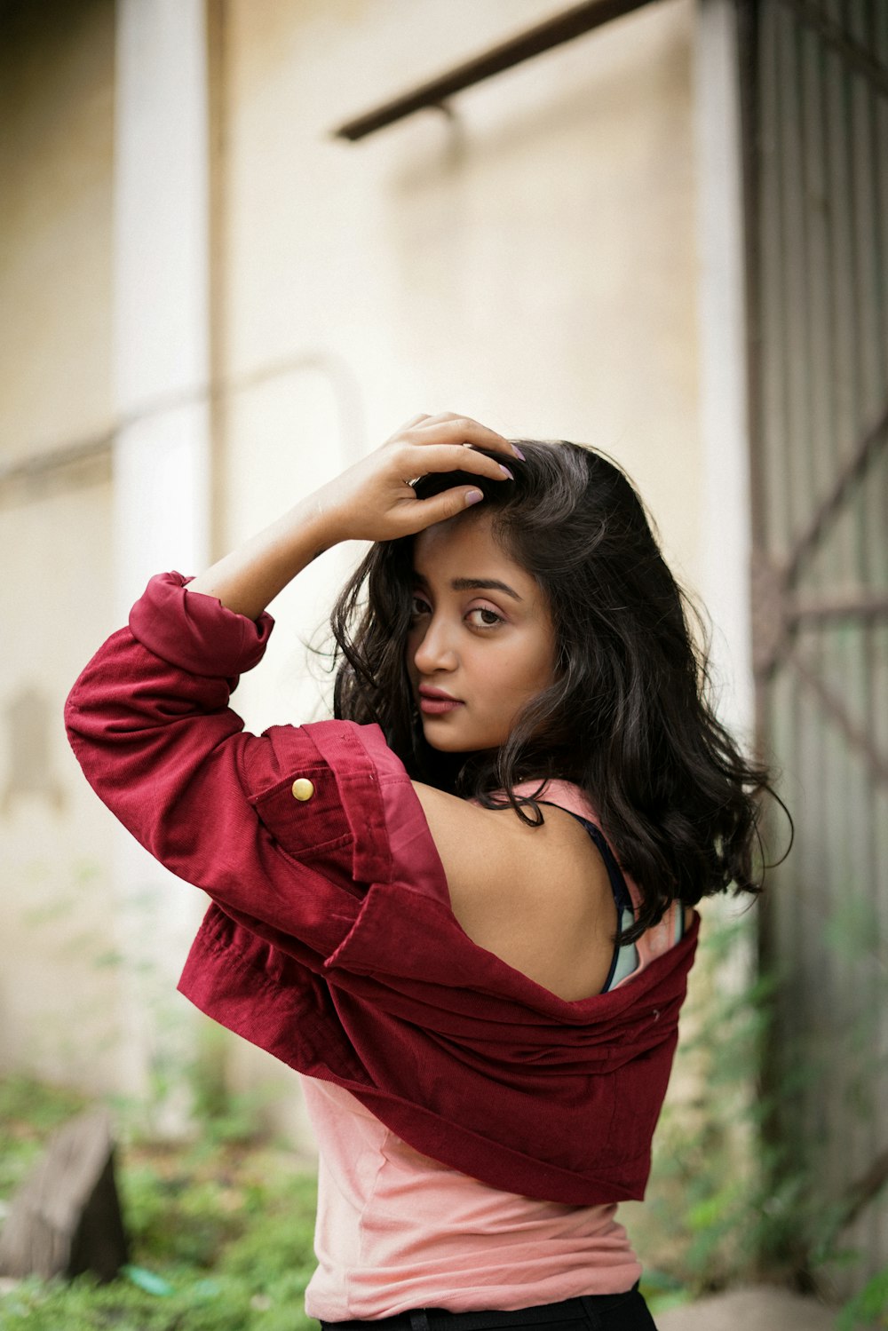 woman in red jacket holding her hair