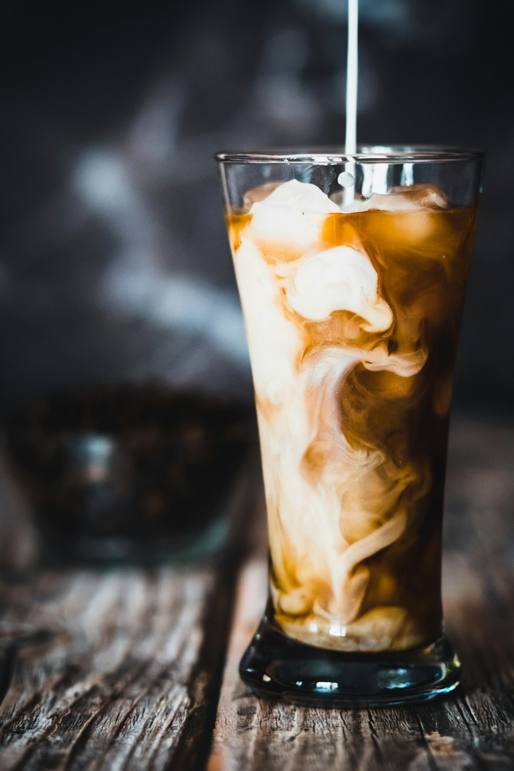 clear drinking glass with ice and brown liquid