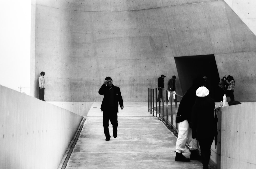 grayscale photo of people walking on hallway