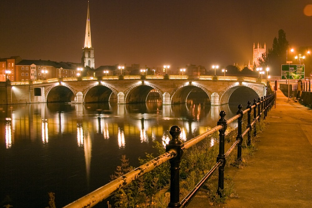 uomo e donna in piedi sul ponte durante la notte