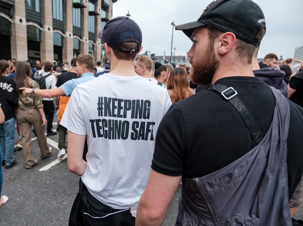 man in white crew neck t-shirt standing beside man in black t-shirt