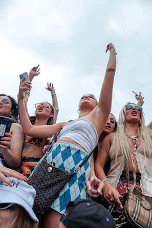 An energetic group photo from a community event, with several people tagging the page on their phones.