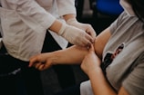 person in white long sleeve shirt holding babys hand