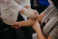 person in white long sleeve shirt holding babys hand