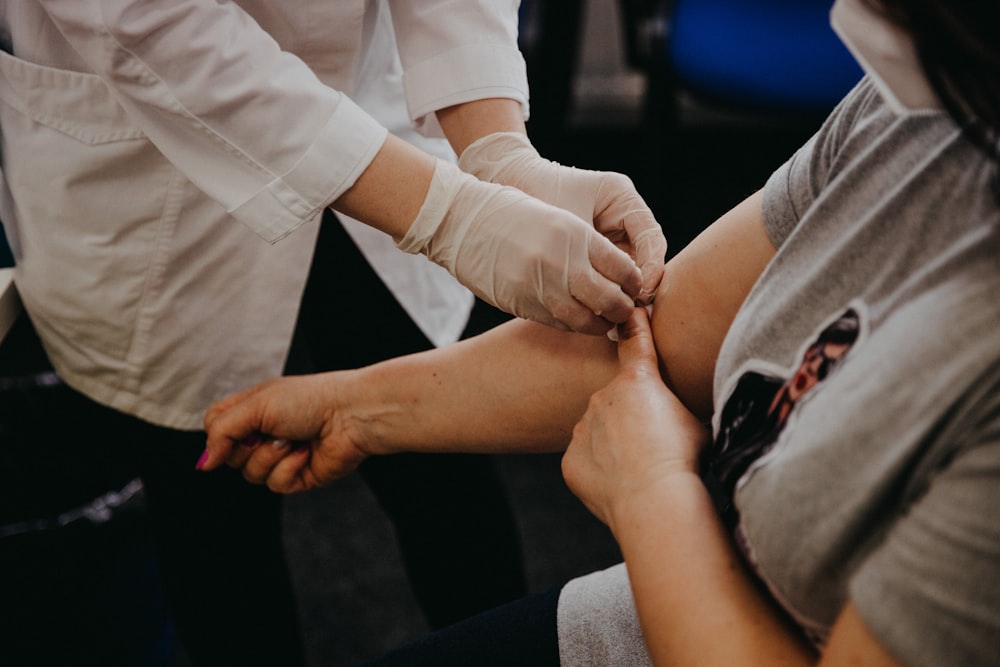 person in white long sleeve shirt holding babys hand