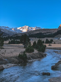 A serene landscape with mountains and a clear blue sky.