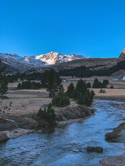 A serene landscape with mountains and a clear blue sky.