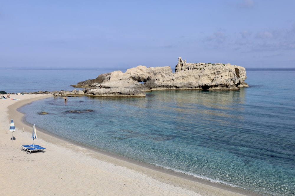 brown rock formation on blue sea water during daytime