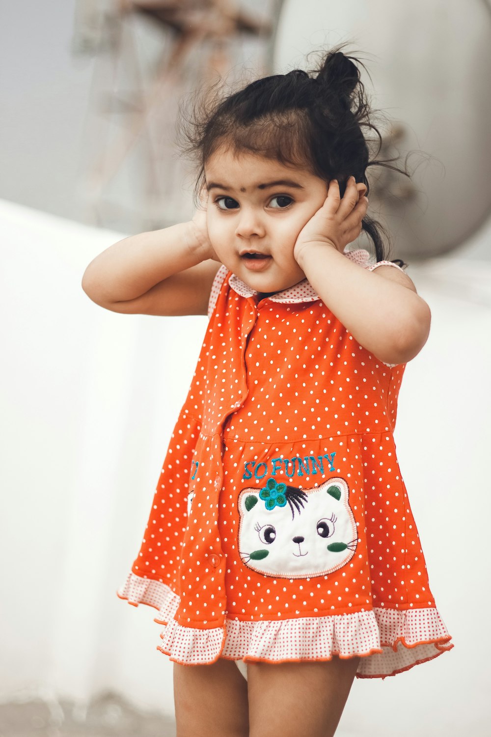 girl in red and white polka dot sleeveless dress