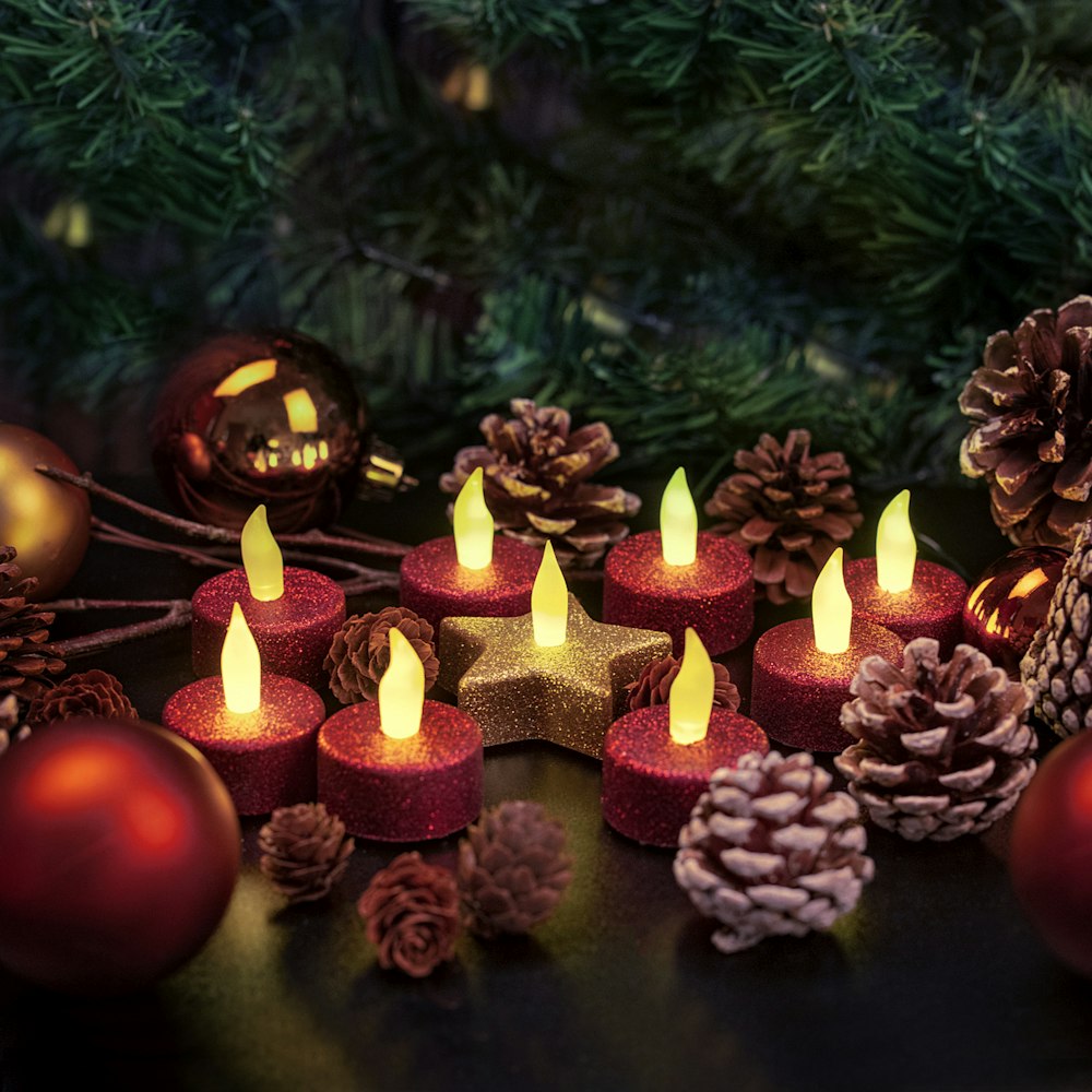 green and brown pine cone with lighted candles