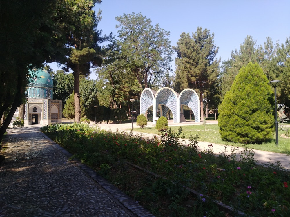 alberi verdi vicino a un edificio in cemento bianco durante il giorno