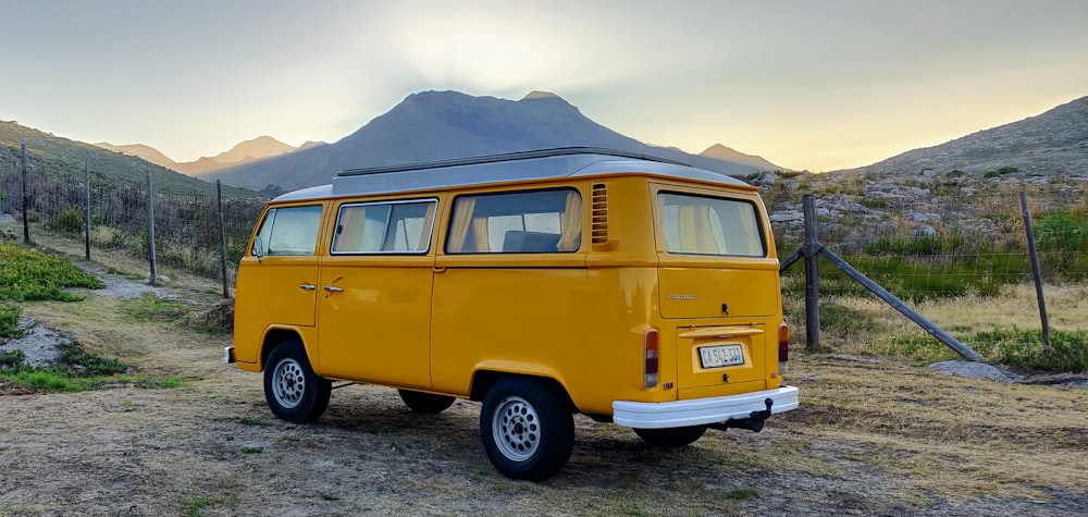 yellow van on gray sand under white sky during daytime