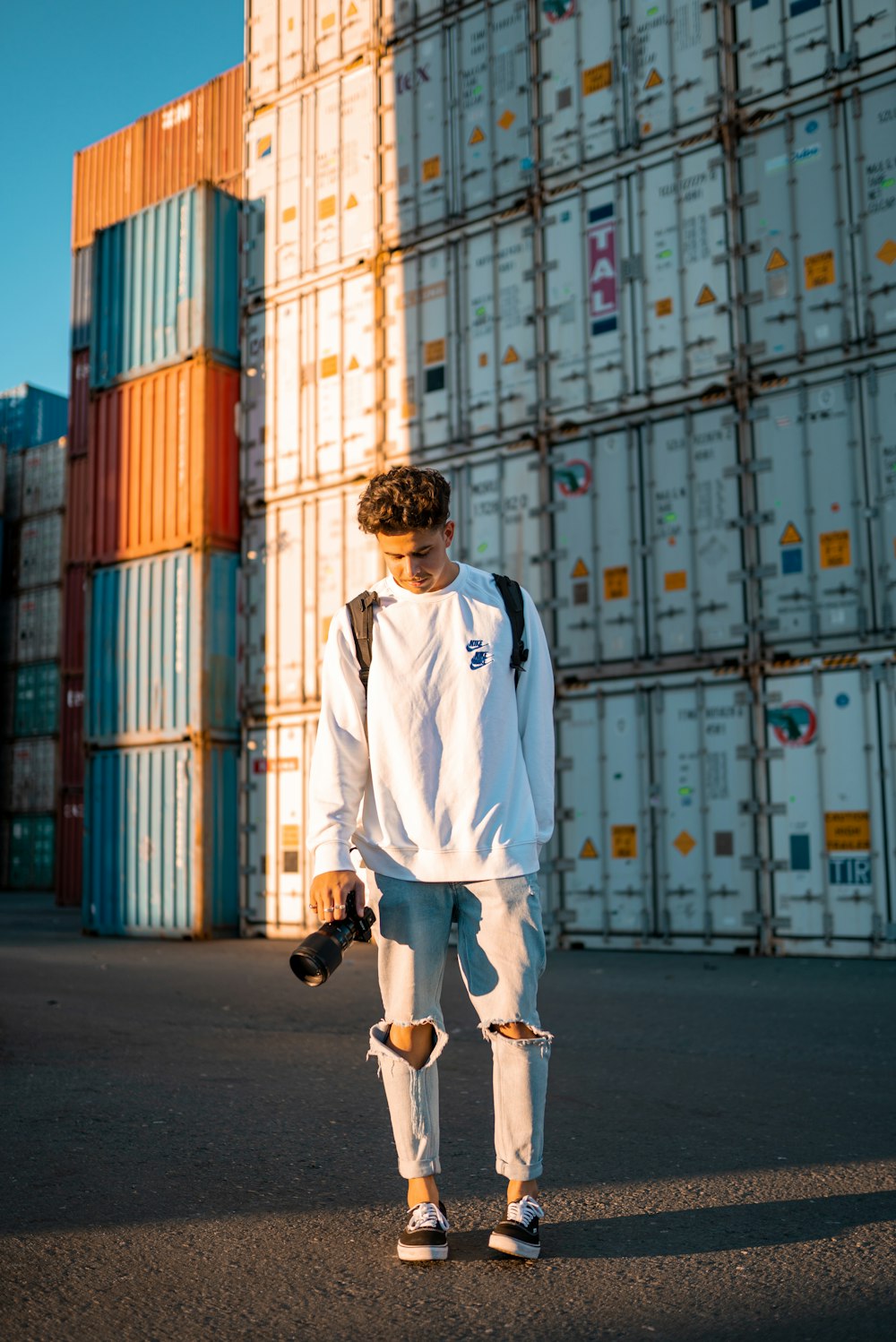 man in white long sleeve shirt and white pants walking on street during daytime