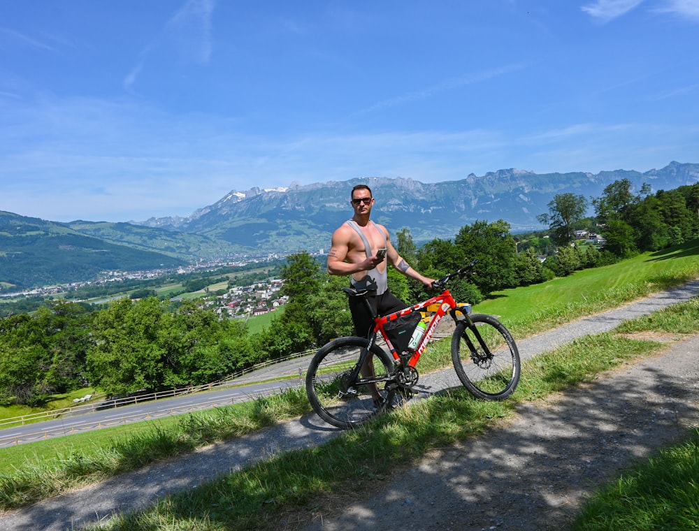 topless man riding on bicycle on road during daytime