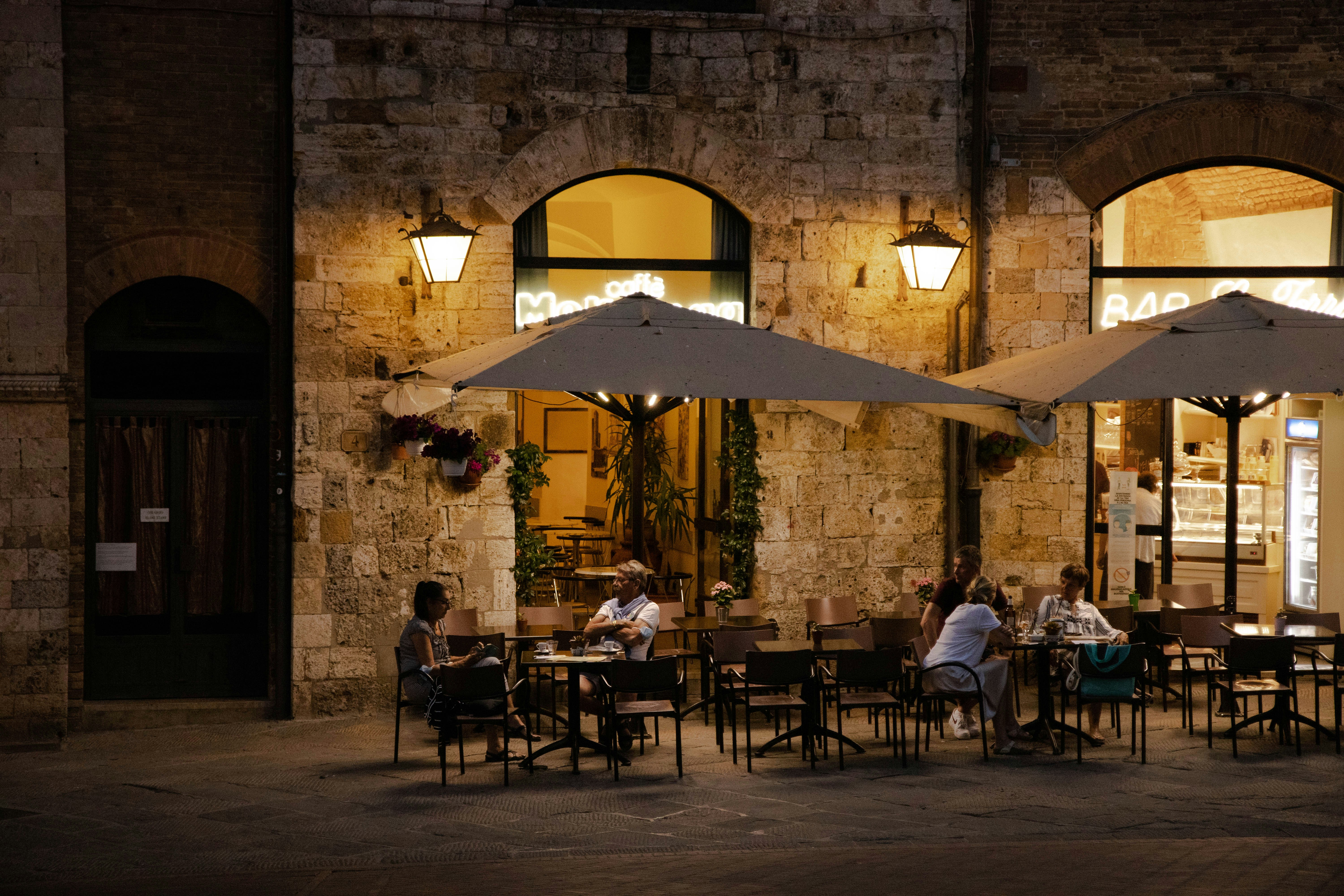 people sitting on chairs near table and chairs during night time