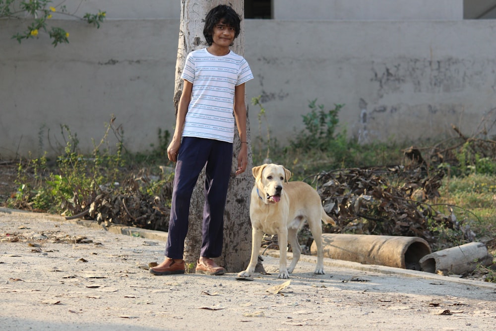 woman in blue shirt and blue denim jeans holding white short coated dog