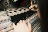 A customer browsing through a crate of classic LPs with focused interest.