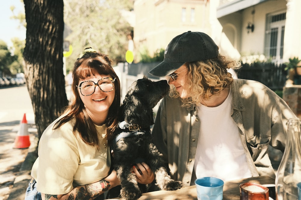 woman in white long sleeve shirt holding black and white short coated small dog