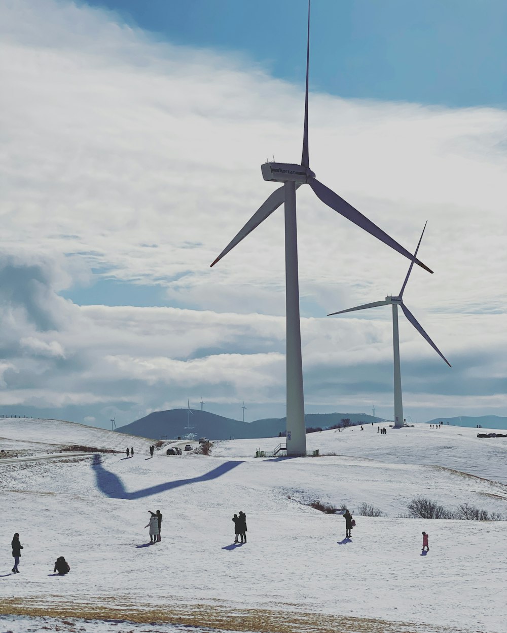 white wind turbine on snow covered ground under cloudy sky during daytime