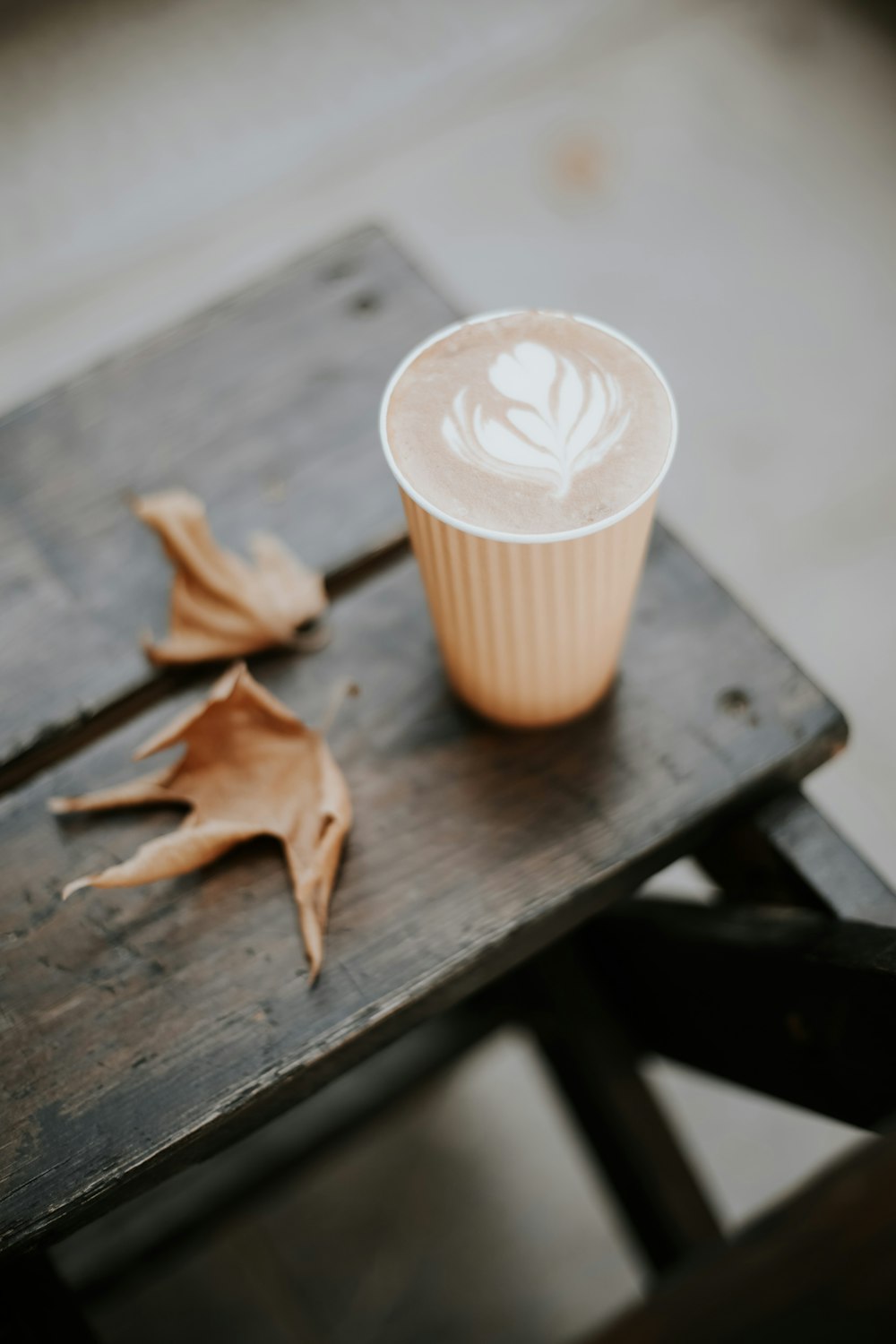 white and brown paper cup on brown wooden table