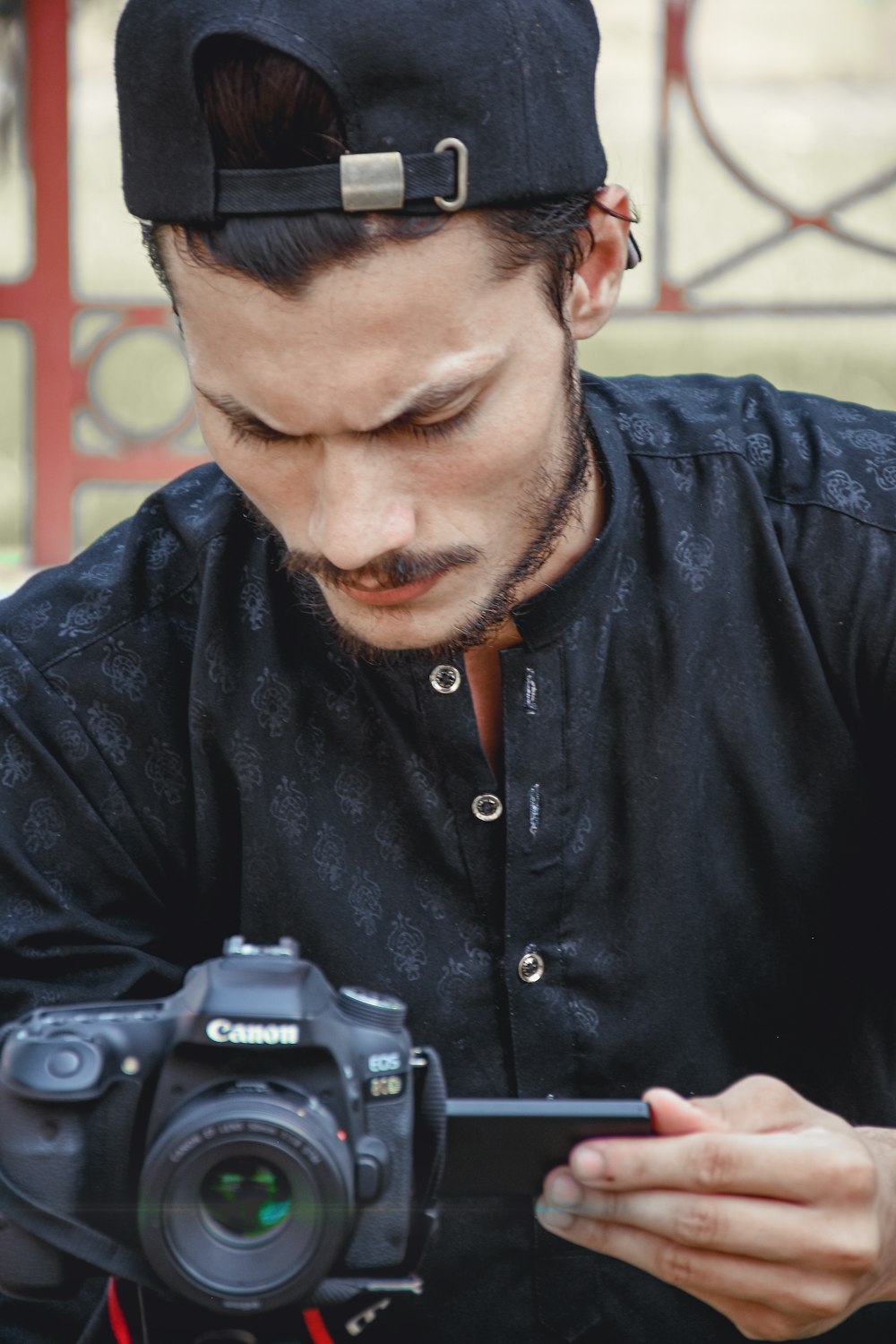 man in black dress shirt holding black and silver dslr camera