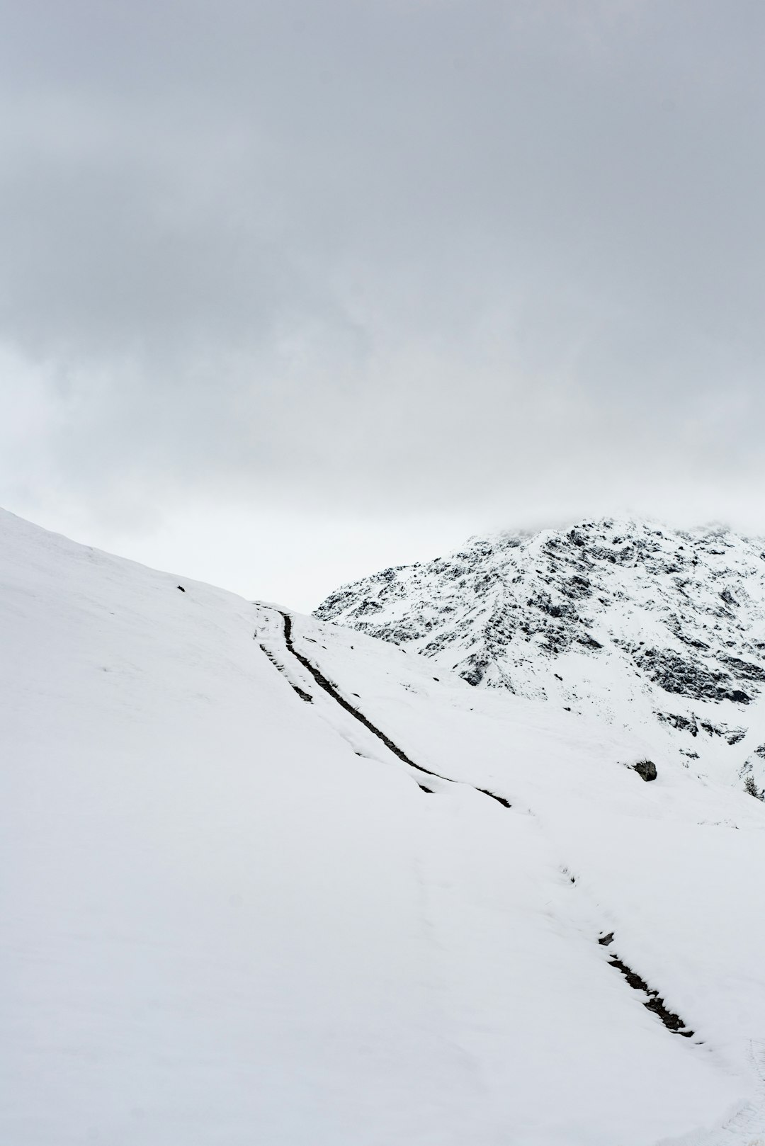 snow covered mountain under cloudy sky during daytime