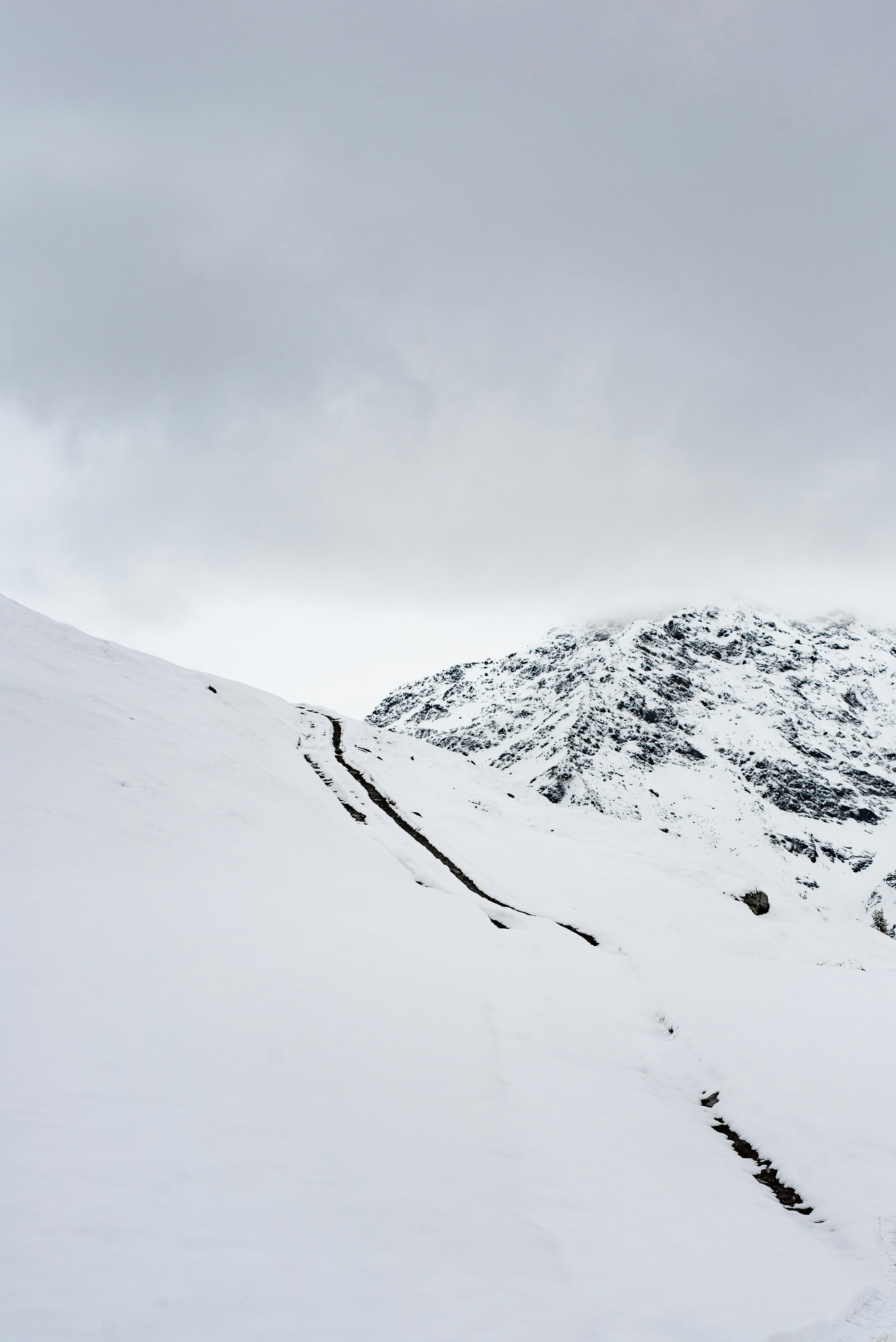 snow covered mountain under cloudy sky during daytime