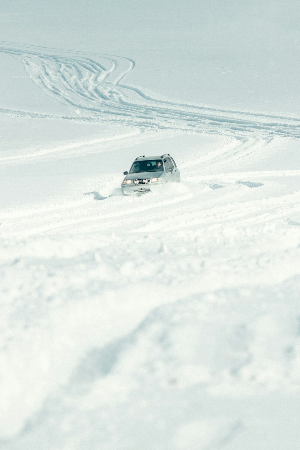 white suv on snow covered ground during daytime