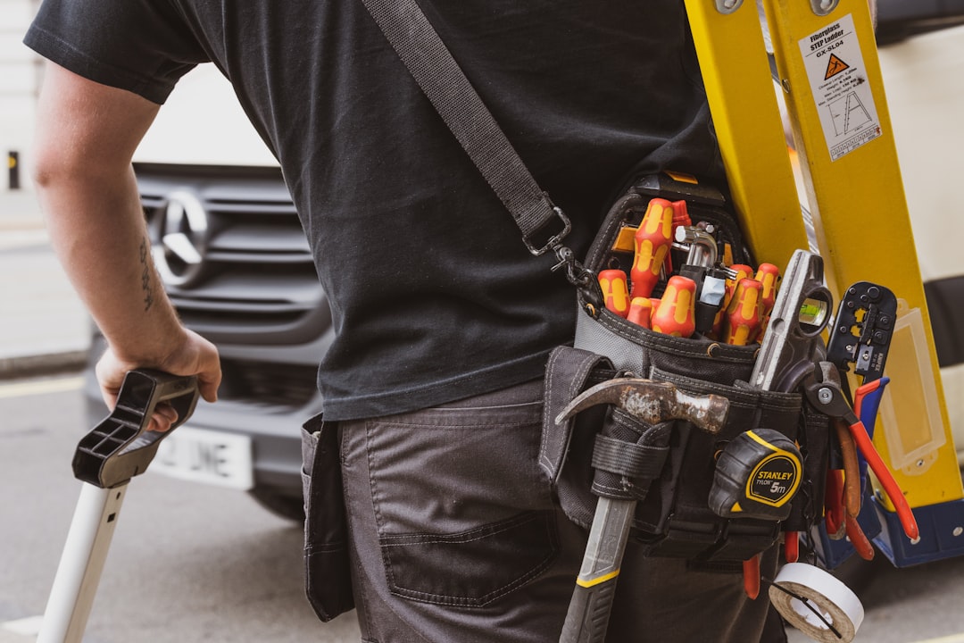 man in black crew neck shirt holding black and yellow power tool