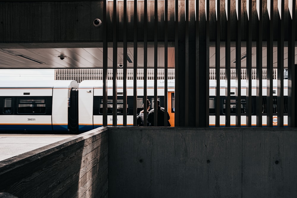 Personas de pie frente al tren blanco y azul durante el día