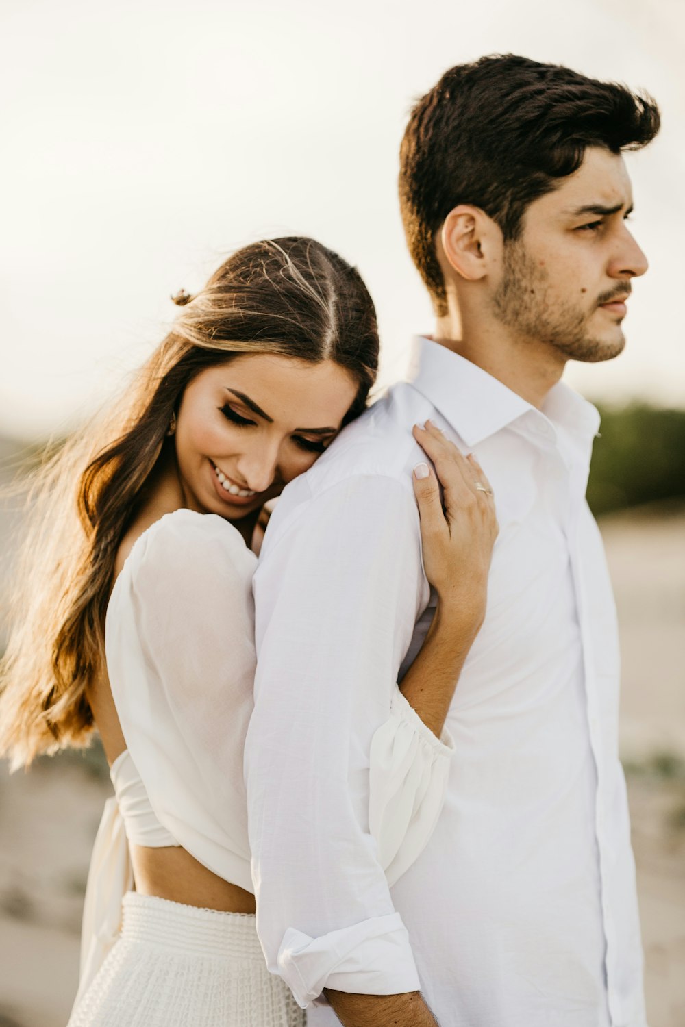 man in white long sleeve shirt hugging woman in white long sleeve shirt