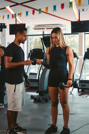 A personal trainer coaching a client through a tailored workout in a bright gym setting.