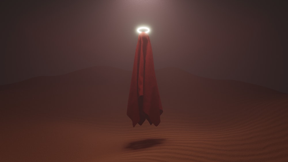 Persona con túnica roja de pie sobre arena marrón durante el día