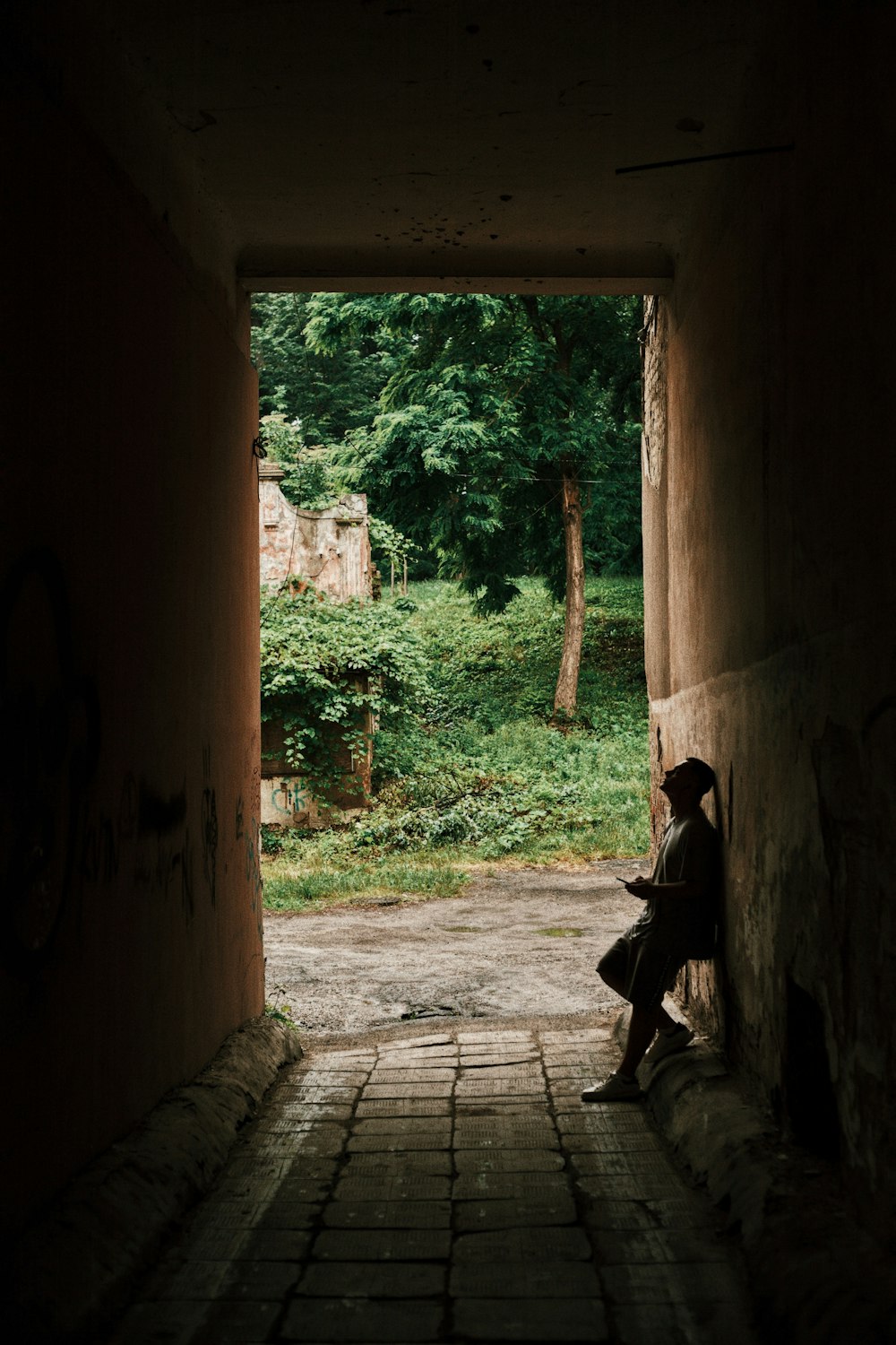 man in black jacket sitting on brown wooden bench during daytime