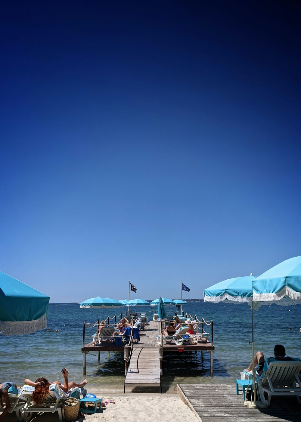 personnes assises sur des chaises de plage sous le ciel bleu pendant la journée